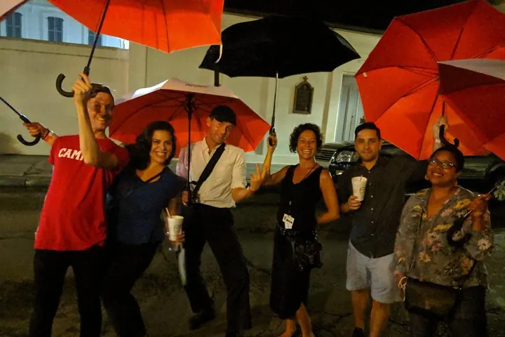 Storyteller guide and group on a New Orleans ghost tour in the French Quarter after dark, Louisiana