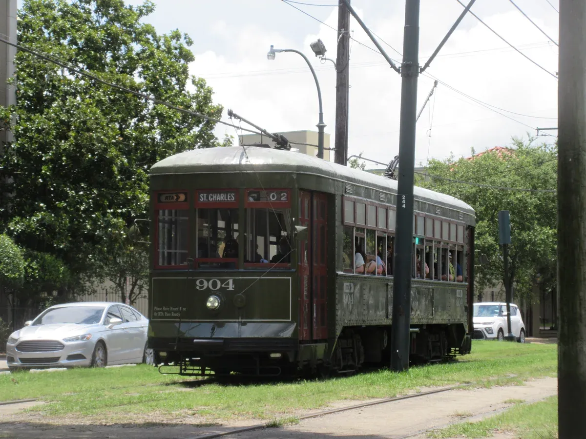 A green St. Charles streetcar in the Garden District, the way to Lafayette Cemetery No. 1 from the French Quarter